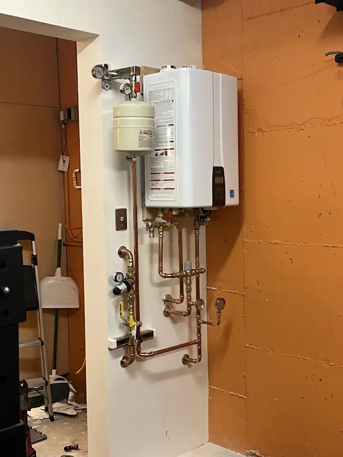 Plumbing technician inspecting water heater connections in Middletown